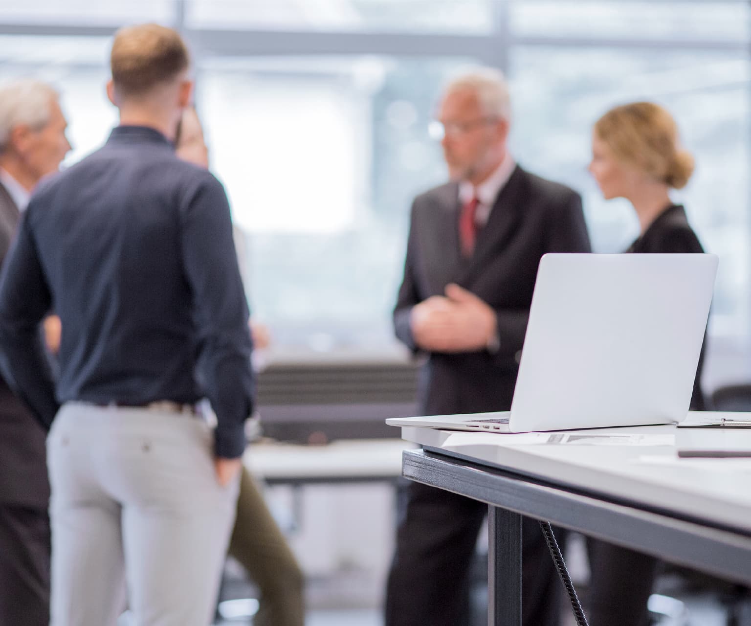 Reunión empresarial con profesionales conversando en una oficina moderna